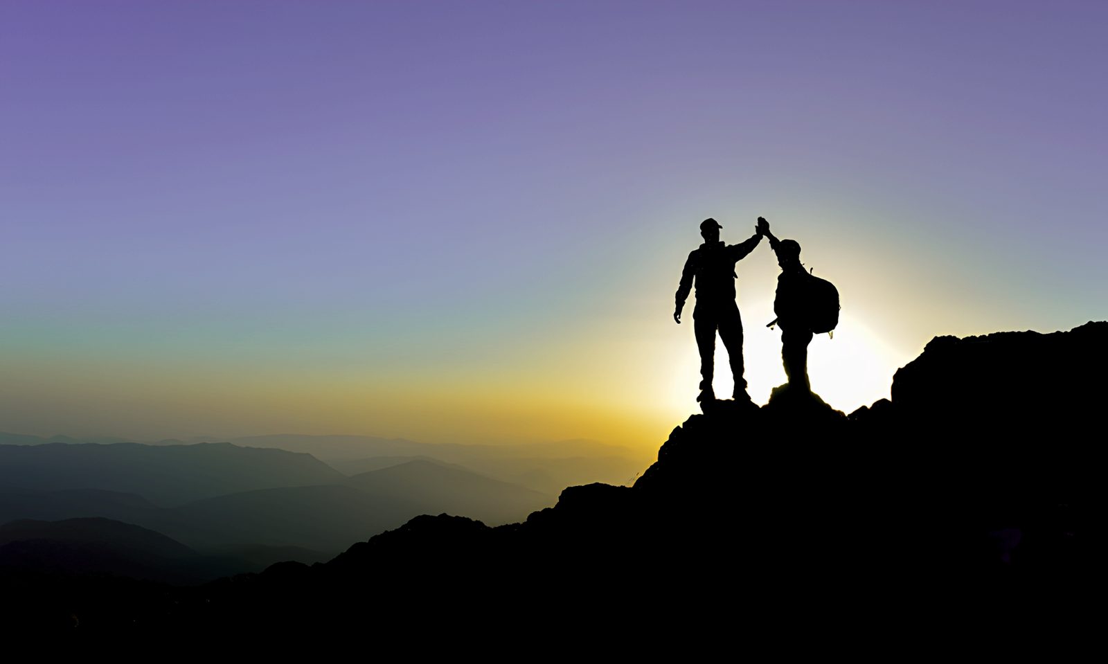 Two people on a summit at sunrise